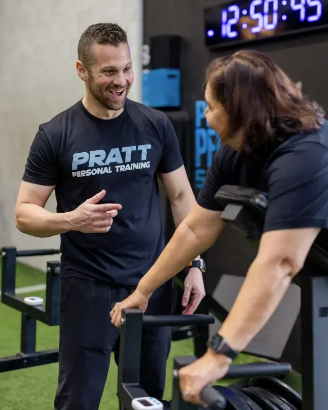 Personal trainer demonstrating proper form to a client